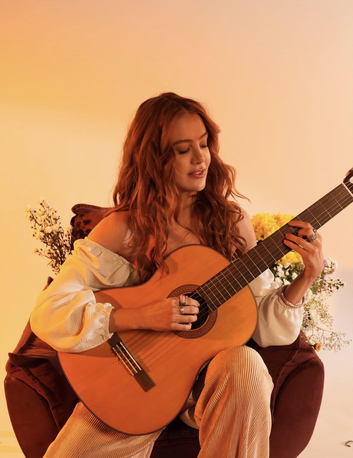 Cantora ruiva tocando violão clássico em ensaio
