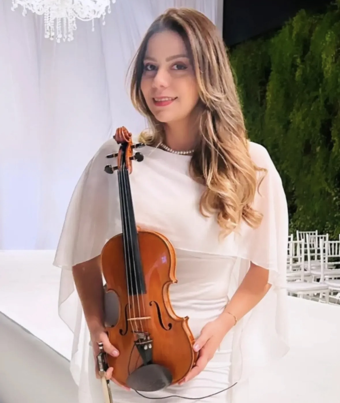 Violinista em vestido branco em cerimônia de casamento