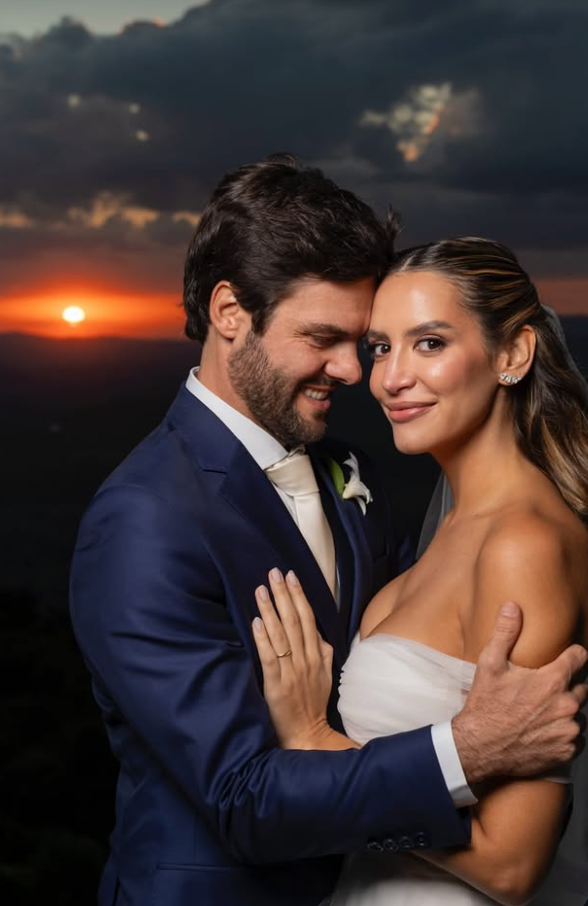 Casal de noivos abraçados ao pôr do sol nas montanhas