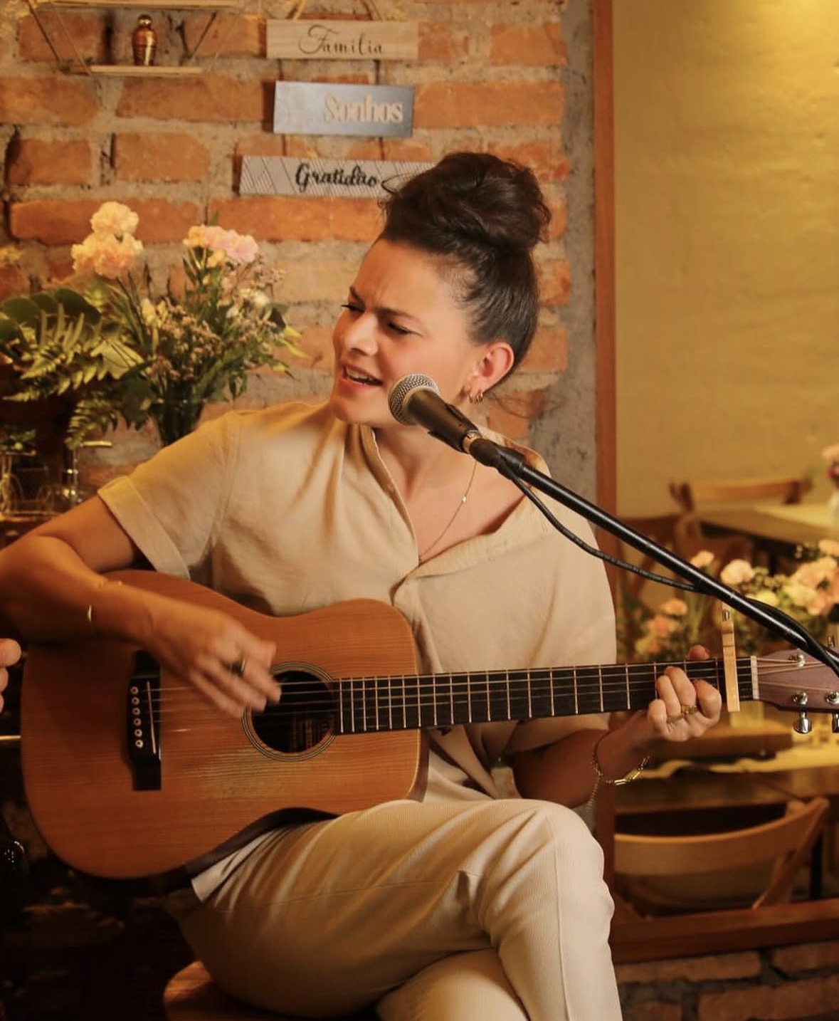 Cantora tocando violão em cerimônia intimista